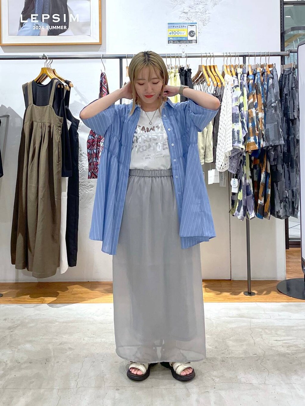 グレー系のスカート、ホワイト系のサンダル、ホワイト系のTシャツ/カットソーを着用したレディースの夏コーディネートの2枚目の写真