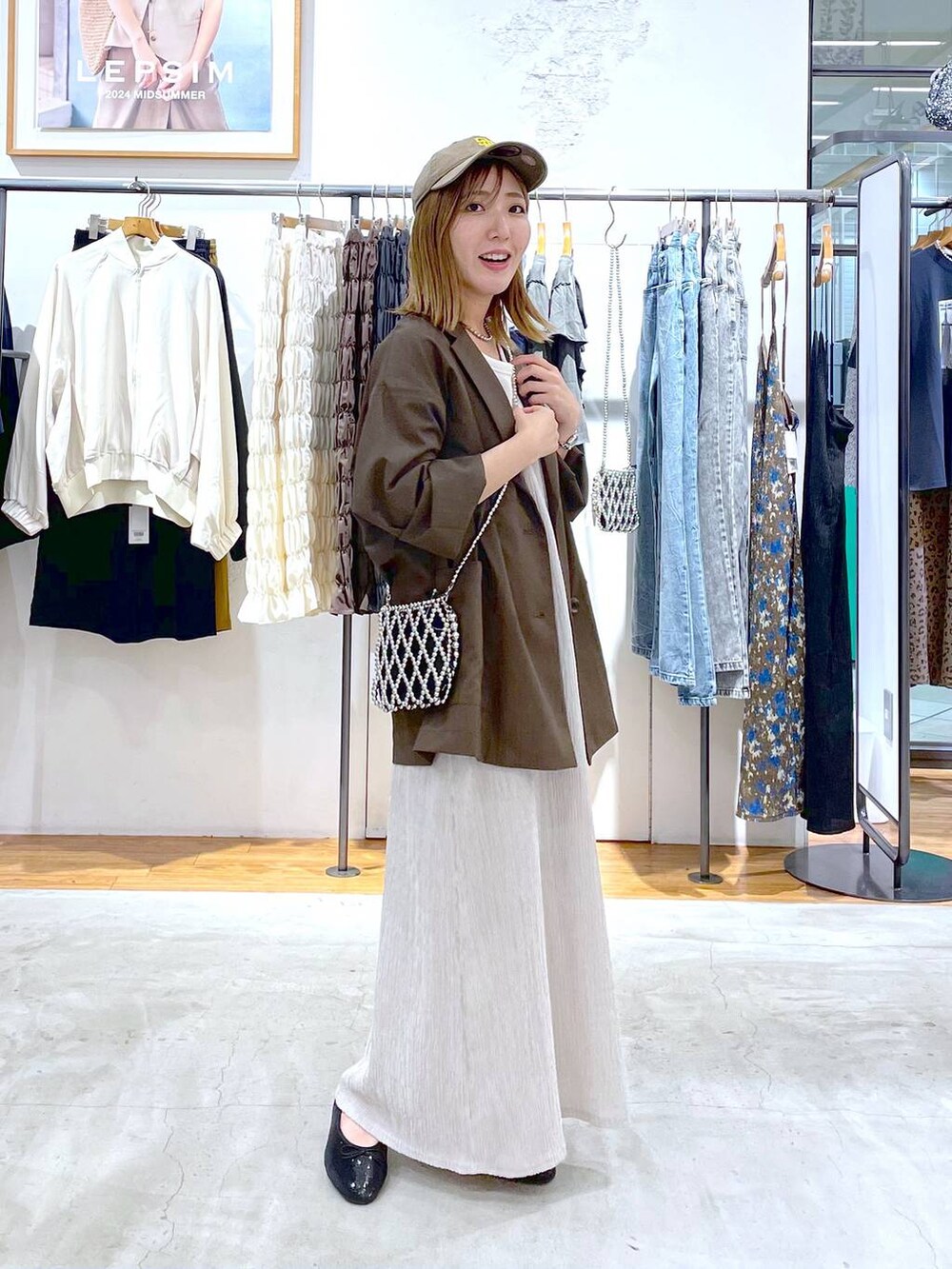 シルバー系のショルダーバッグ、ホワイト系のタンクトップ、ブラック系のバレエシューズを着用したレディースの秋コーディネートの2枚目の写真