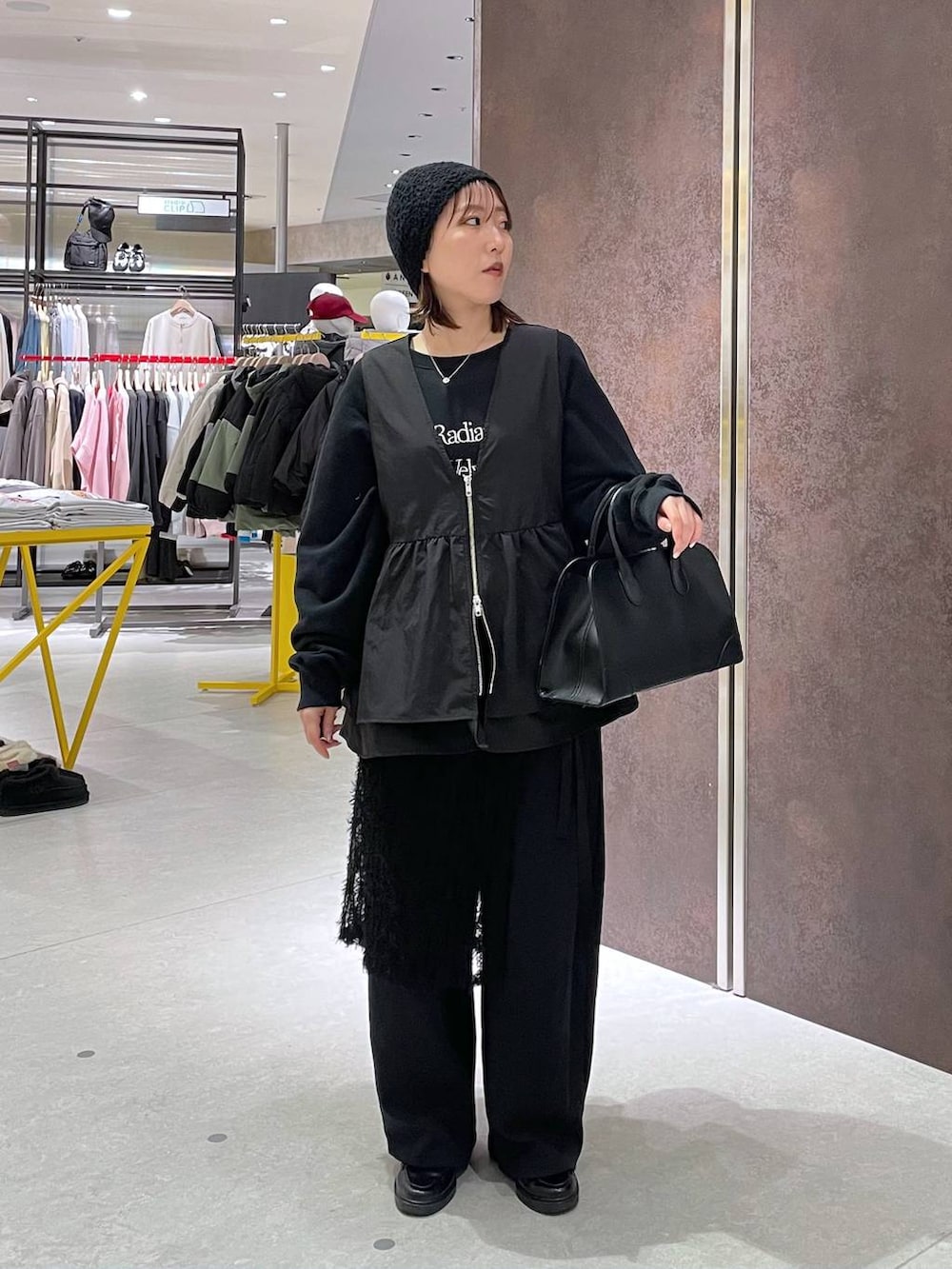 ブラック系のショルダーバッグ、ブラック系のベストを着用したレディースの春コーディネートの3枚目の写真