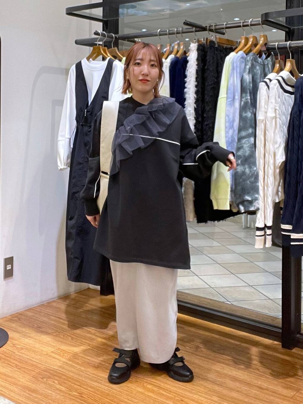 ホワイト系のショルダーバッグ、グレー系のスカート、ブラック系のスニーカーを着用したレディースの春コーディネートの4枚目の写真