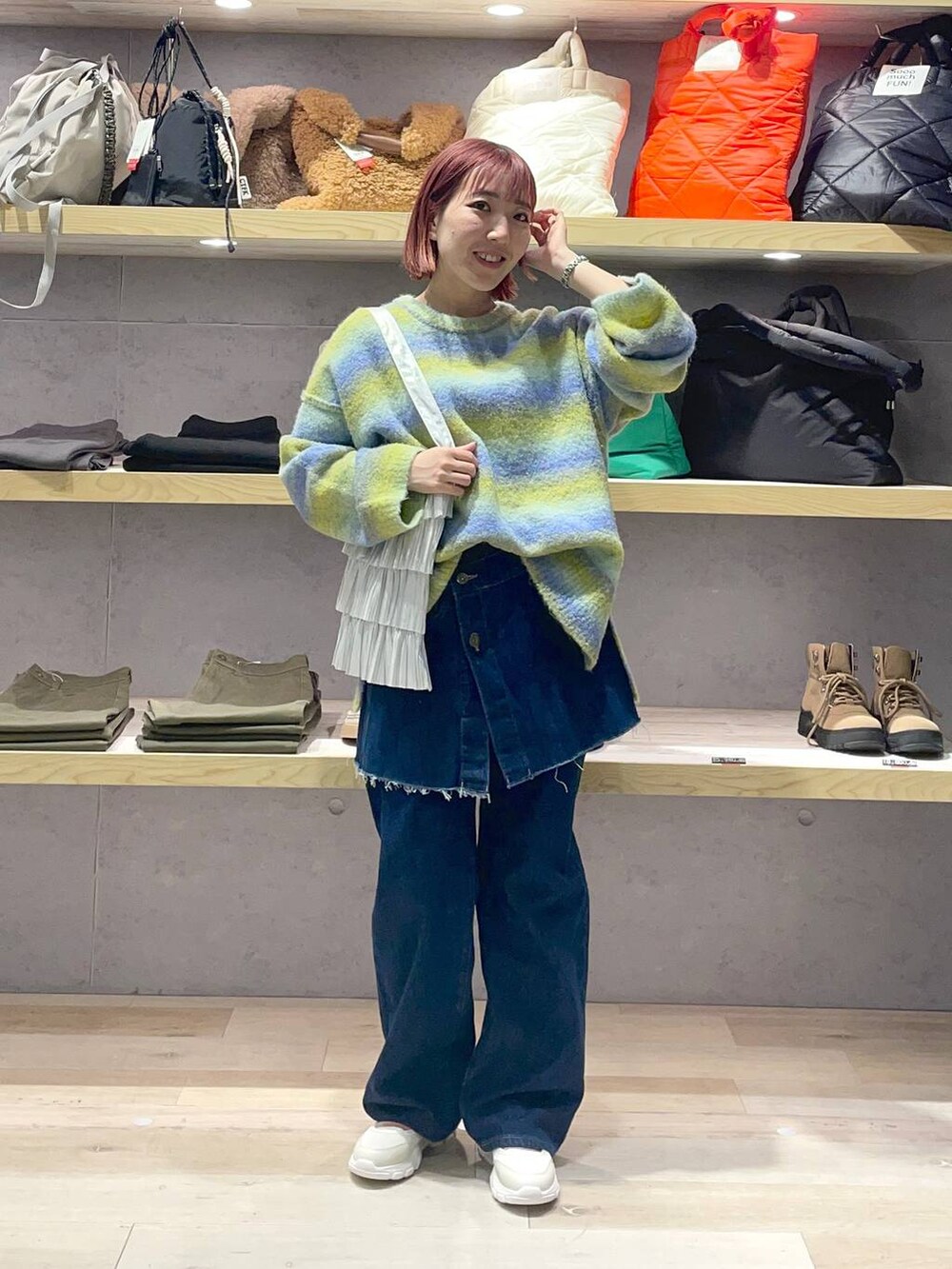 ホワイト系のスニーカー、シルバー系のトートバッグ、グリーン系のニット/セーターを着用したレディースの冬コーディネートの2枚目の写真