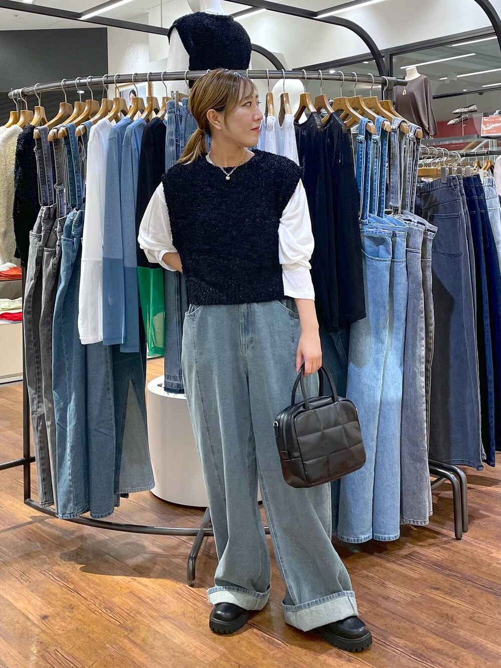 ホワイト系のTシャツ/カットソー、ブルー系のデニムパンツ、ブラック系のボストンバッグを着用したレディースの秋コーディネートの2枚目の写真