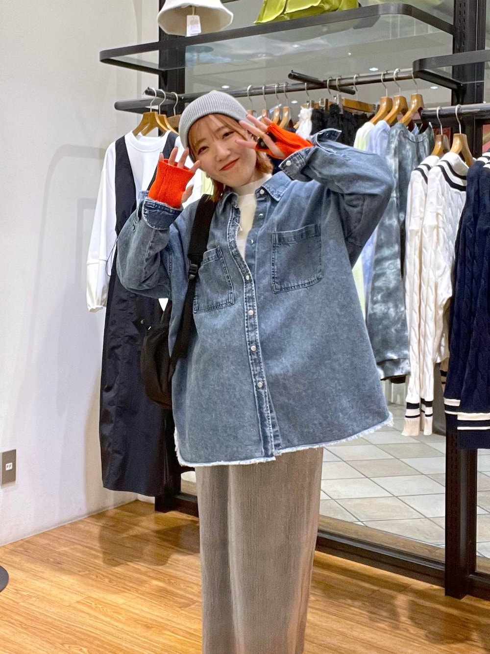 グレー系のスカート、ブラック系のバックパック/リュック、ブルー系のシャツ/ブラウスを着用したレディースの冬コーディネートの2枚目の写真