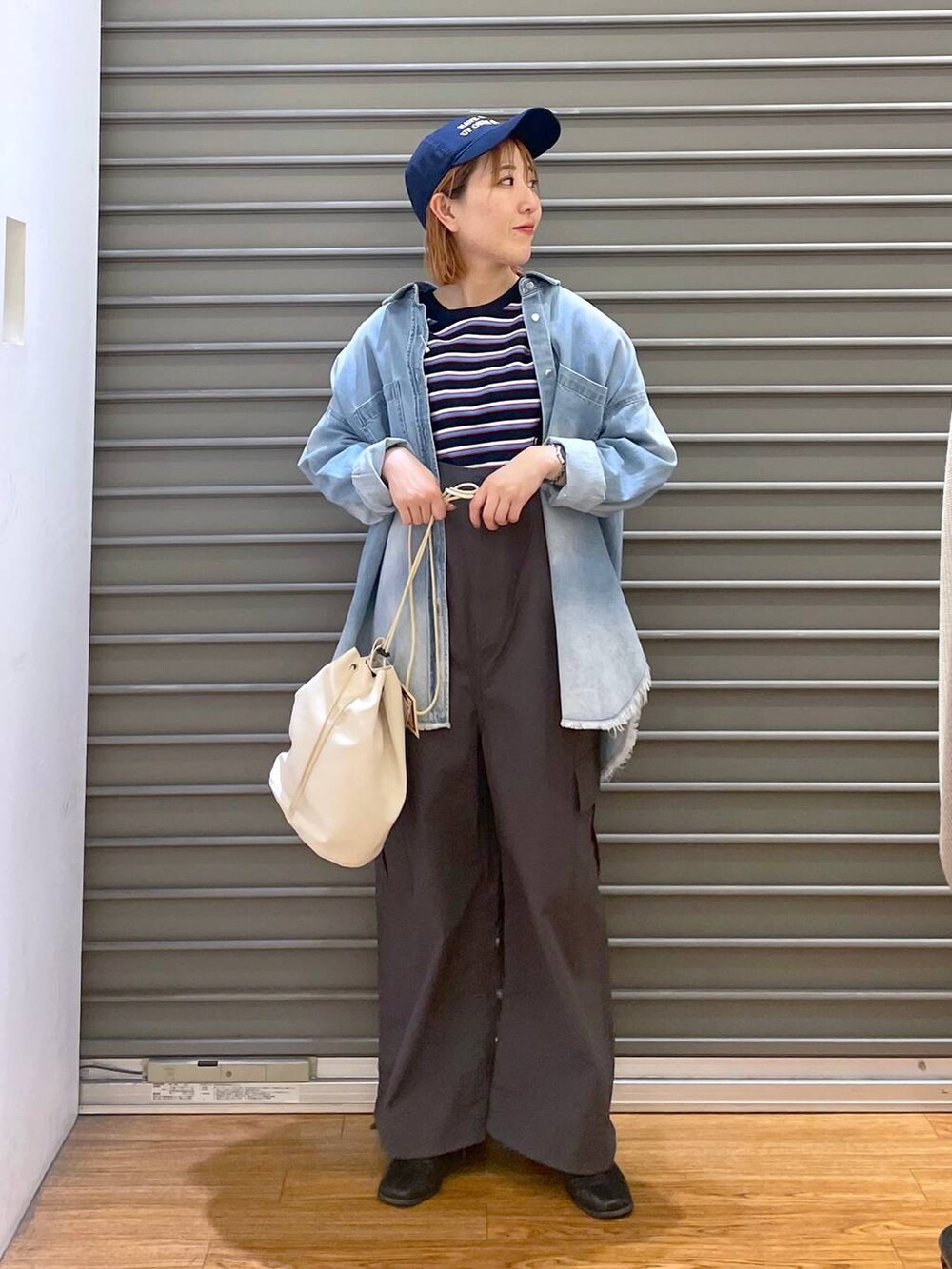 グレー系のサロペット/オーバーオール、ブルー系のシャツ/ブラウス、ブルー系のTシャツ/カットソーを着用したレディースの春コーディネートの3枚目の写真