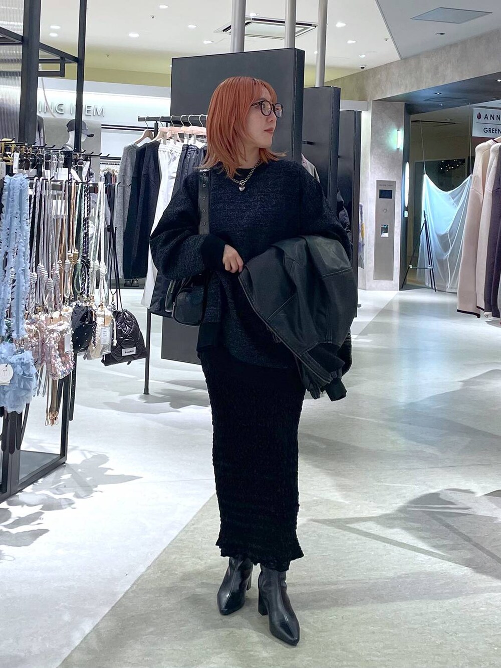 ブラック系のショルダーバッグ、ブラック系のブーツ、ブラック系のニット/セーターを着用したレディースの冬コーディネートの2枚目の写真