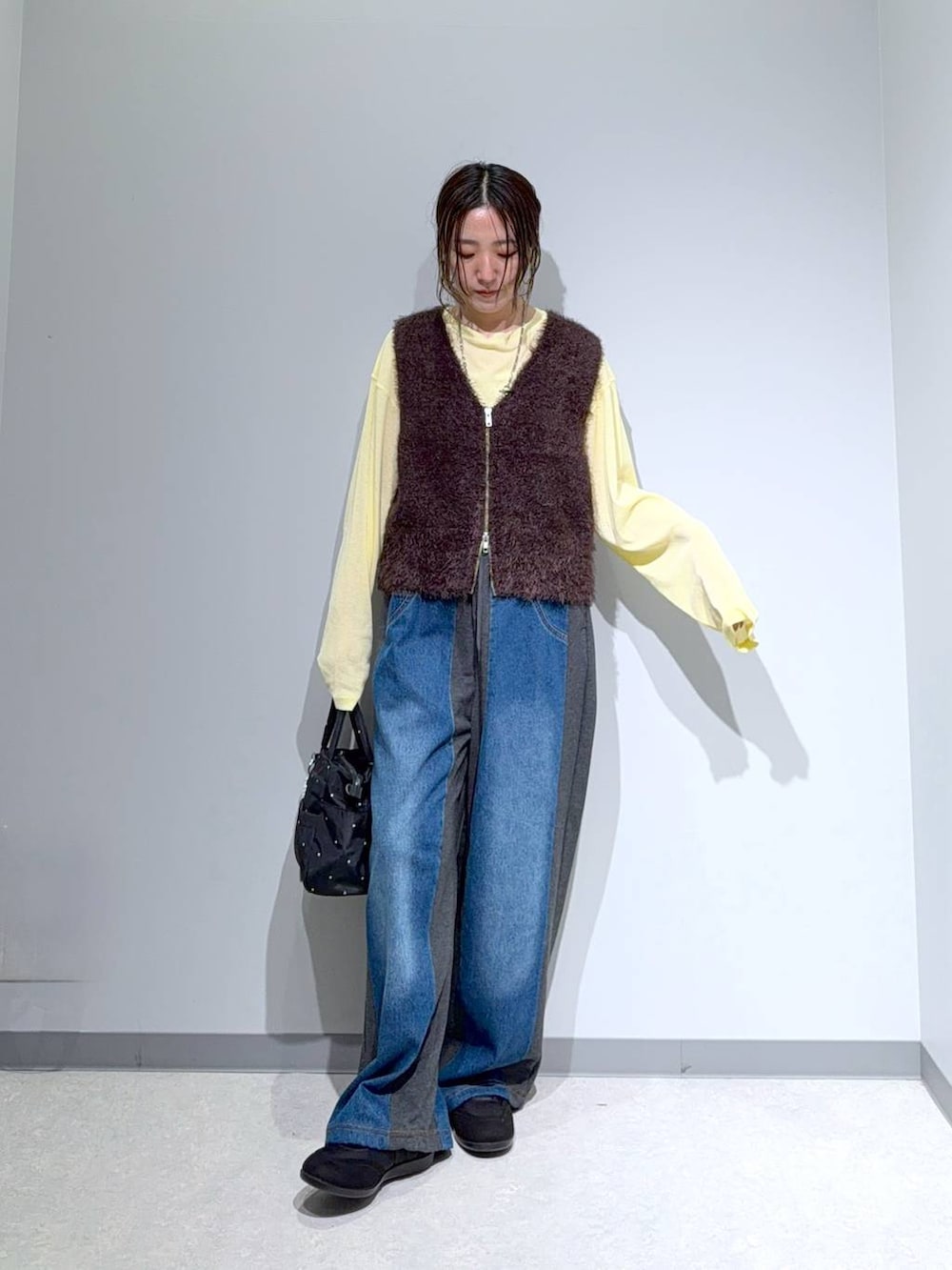 ブラック系のパンプス、グレー系のデニムパンツ、イエロー系のTシャツ/カットソーを着用したレディースの秋コーディネートの2枚目の写真