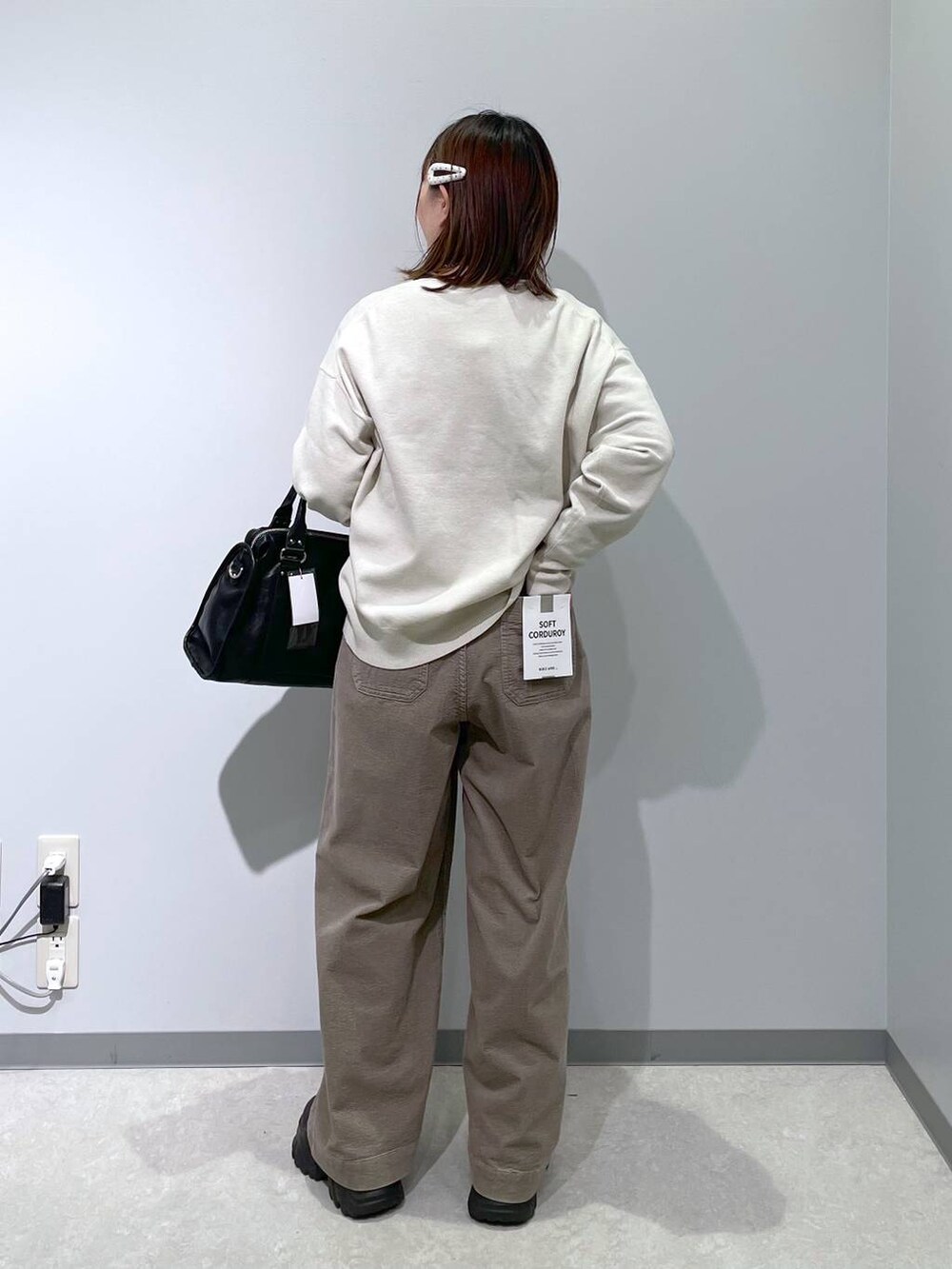 ブラック系のボストンバッグ、ベージュ系のその他パンツ、グレー系のニット/セーターを着用したレディースの冬コーディネートの2枚目の写真