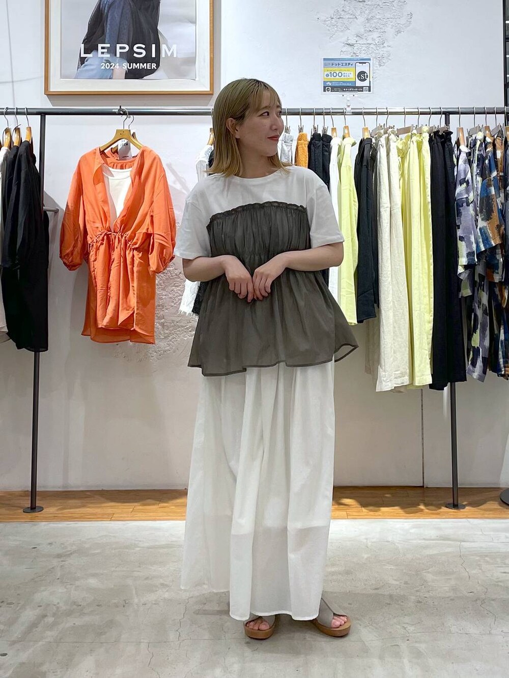 ホワイト系のスカート、グリーン系のTシャツ/カットソー、ベージュ系のサンダルを着用したレディースの夏コーディネートの2枚目の写真