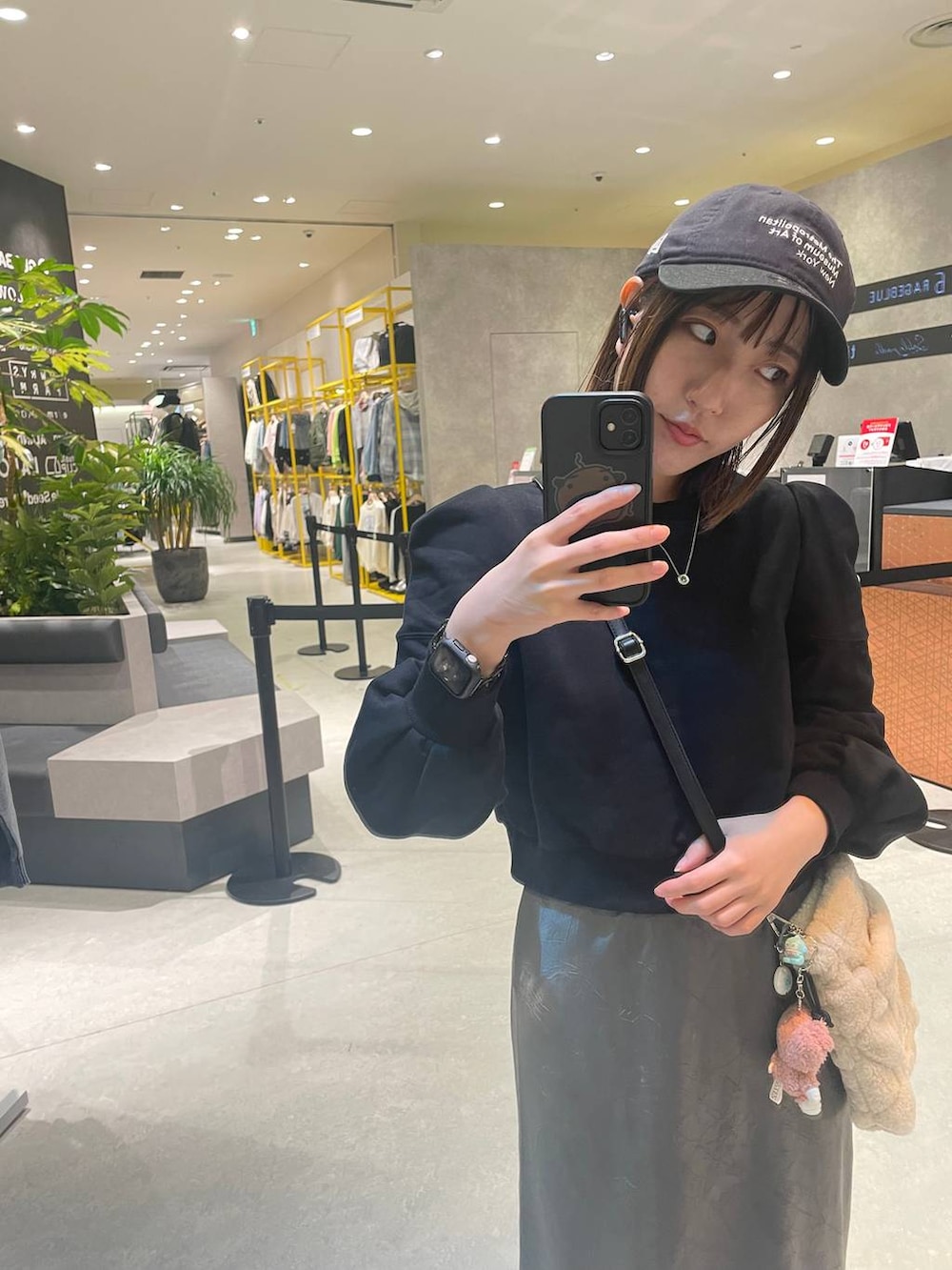 グレー系のスカート、ブラック系のスウェットを着用したレディースの秋コーディネートの2枚目の写真