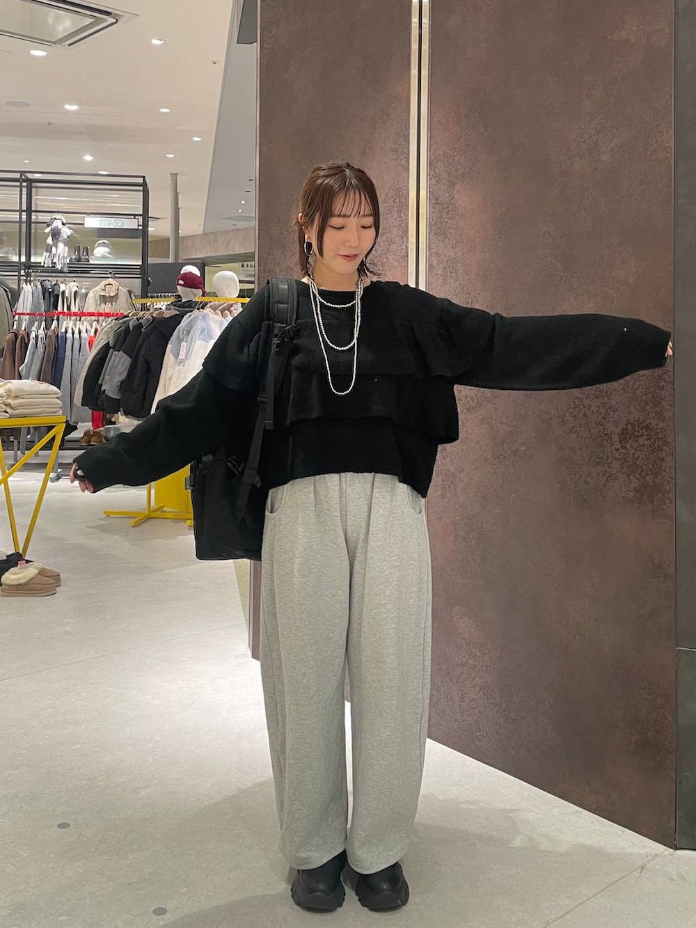 ブラック系のバックパック/リュック、グレー系のスウェットパンツ、ブラック系のニット/セーターを着用したレディースの冬コーディネートの4枚目の写真