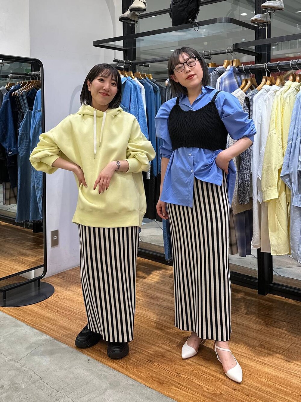 ブルー系のシャツ/ブラウス、ブラック系のニット/セーター、イエロー系のパーカーを着用したレディースの春コーディネートの4枚目の写真