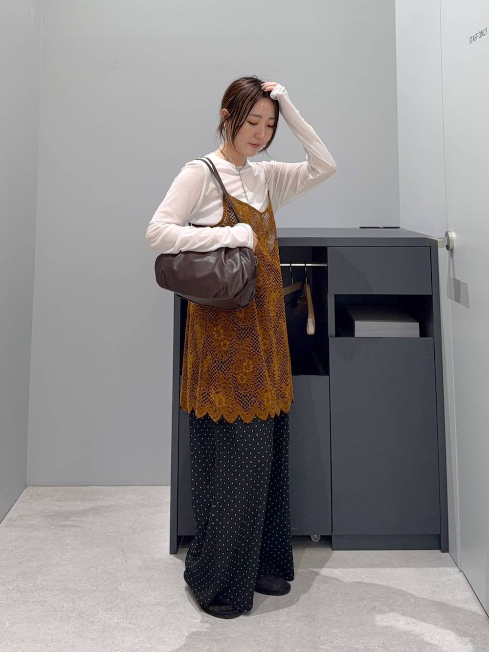 オレンジ系のキャミソール、ブラウン系のボストンバッグ、ホワイト系のTシャツ/カットソーを着用したレディースの夏コーディネートの2枚目の写真