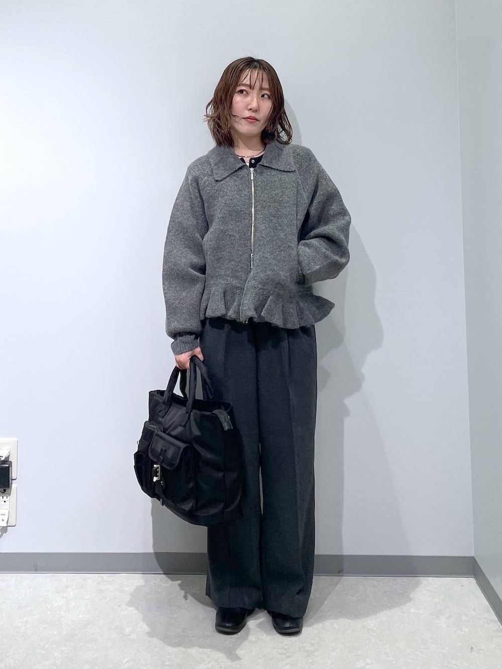 ブラック系のトートバッグ、グレー系のブルゾンを着用したレディースの冬コーディネートの4枚目の写真