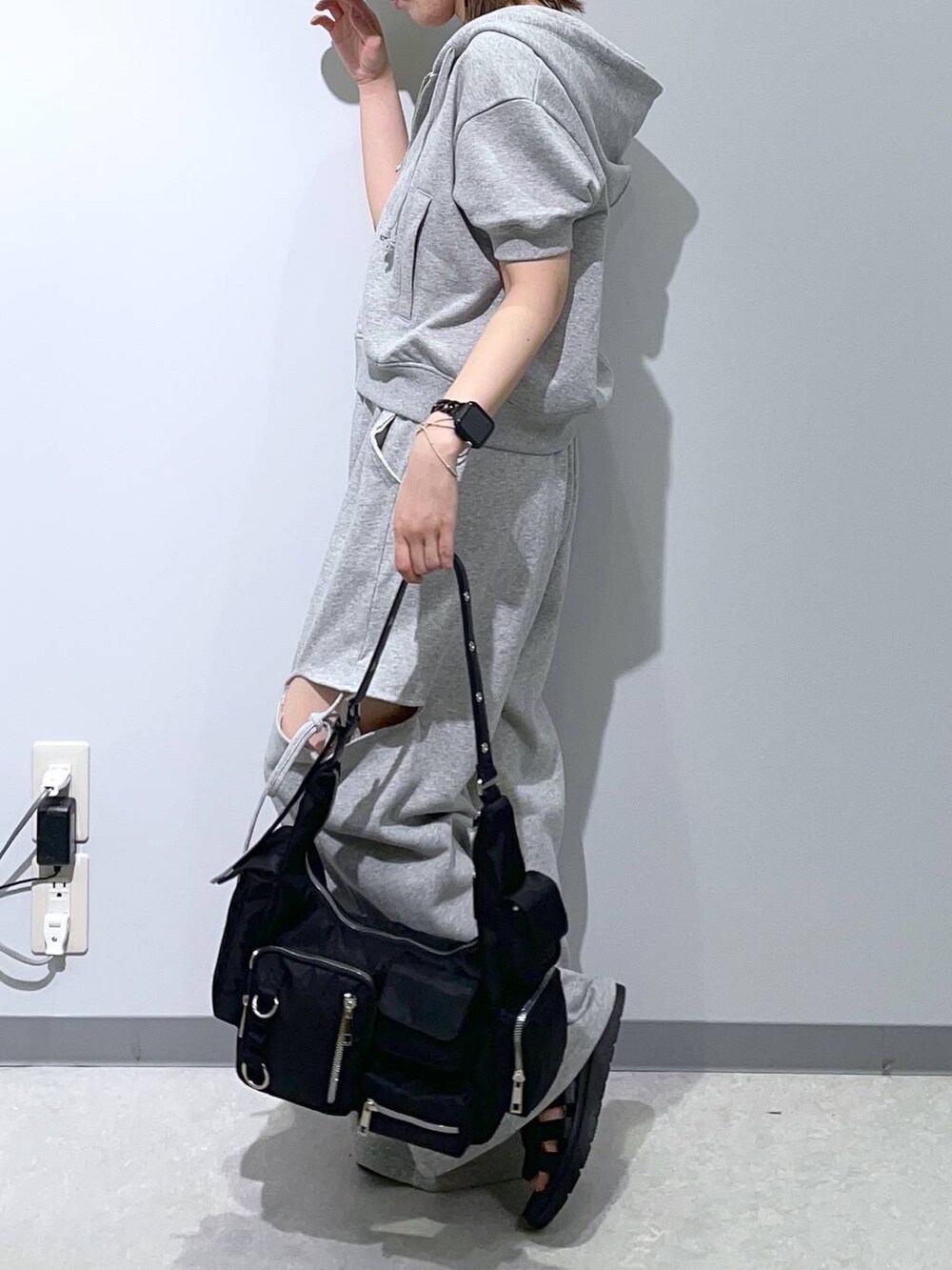 ブラック系のサンダル、グレー系のスウェットパンツ、ブラック系のショルダーバッグを着用したレディースの夏コーディネートの3枚目の写真
