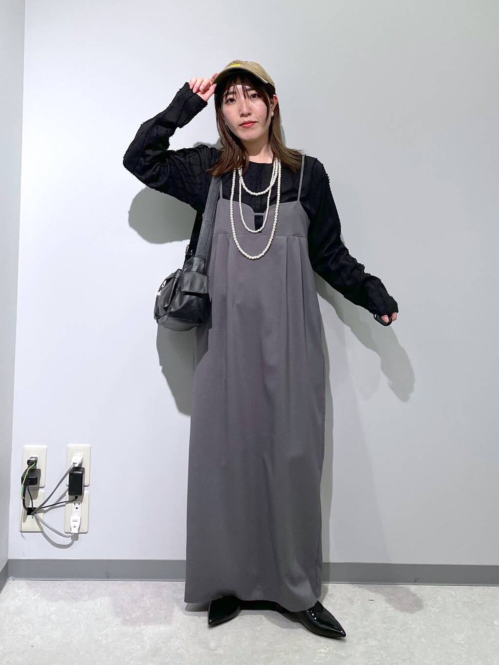 ブラック系のTシャツ/カットソー、ブラック系のショルダーバッグ、ブラック系のパンプスを着用したレディースの春コーディネートの3枚目の写真