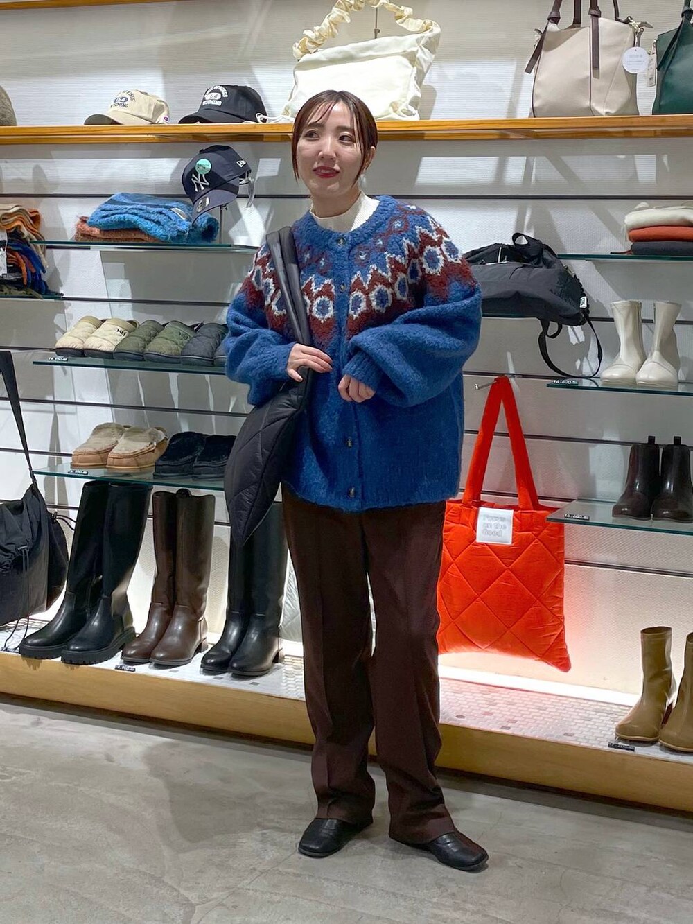 ホワイト系のニット/セーター、ブラウン系のその他パンツ、ブラック系のトートバッグを着用したレディースの冬コーディネートの2枚目の写真