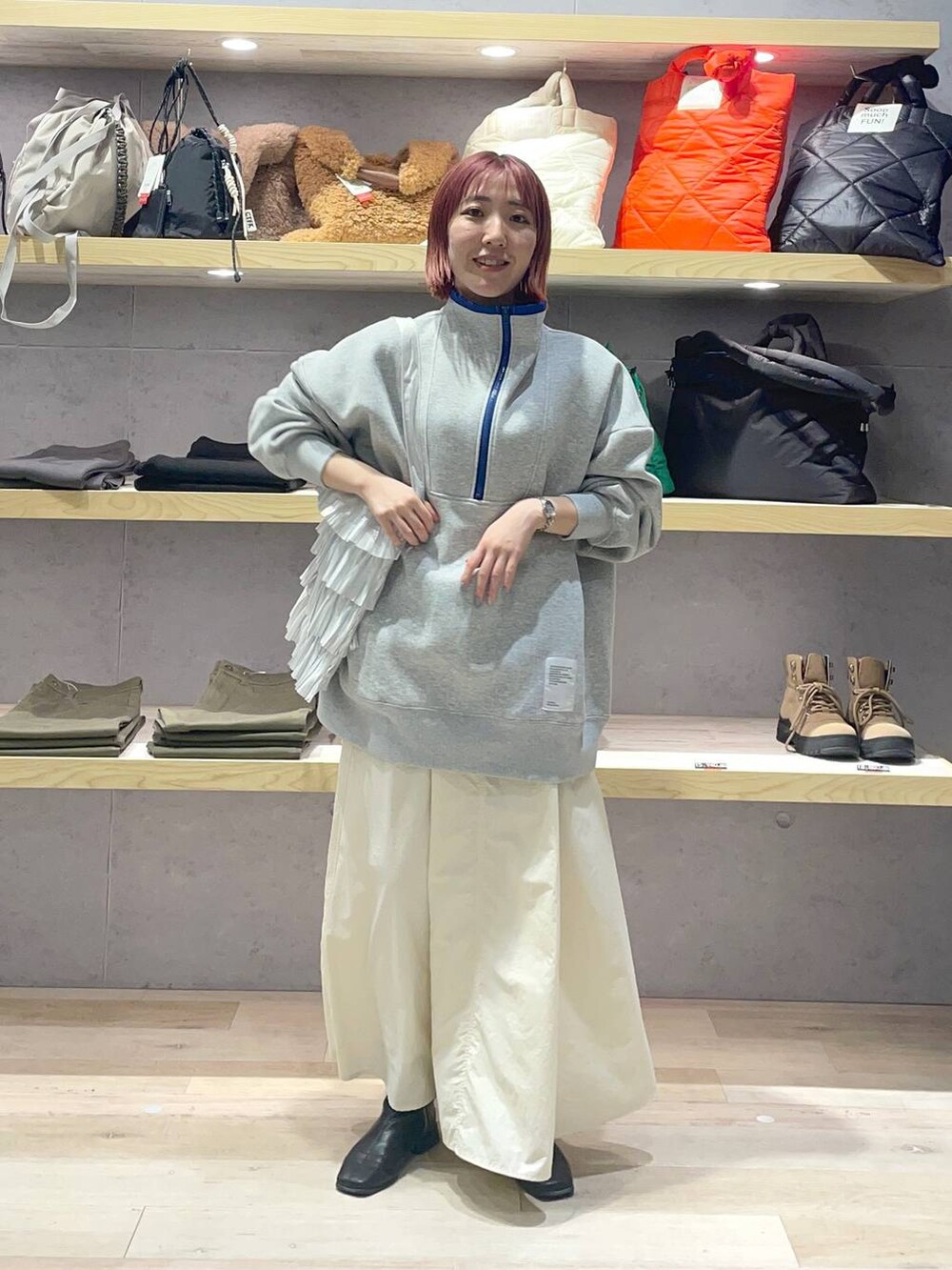 グレー系のTシャツ/カットソー、シルバー系のトートバッグ、ホワイト系のスカートを着用したレディースの冬コーディネートの3枚目の写真