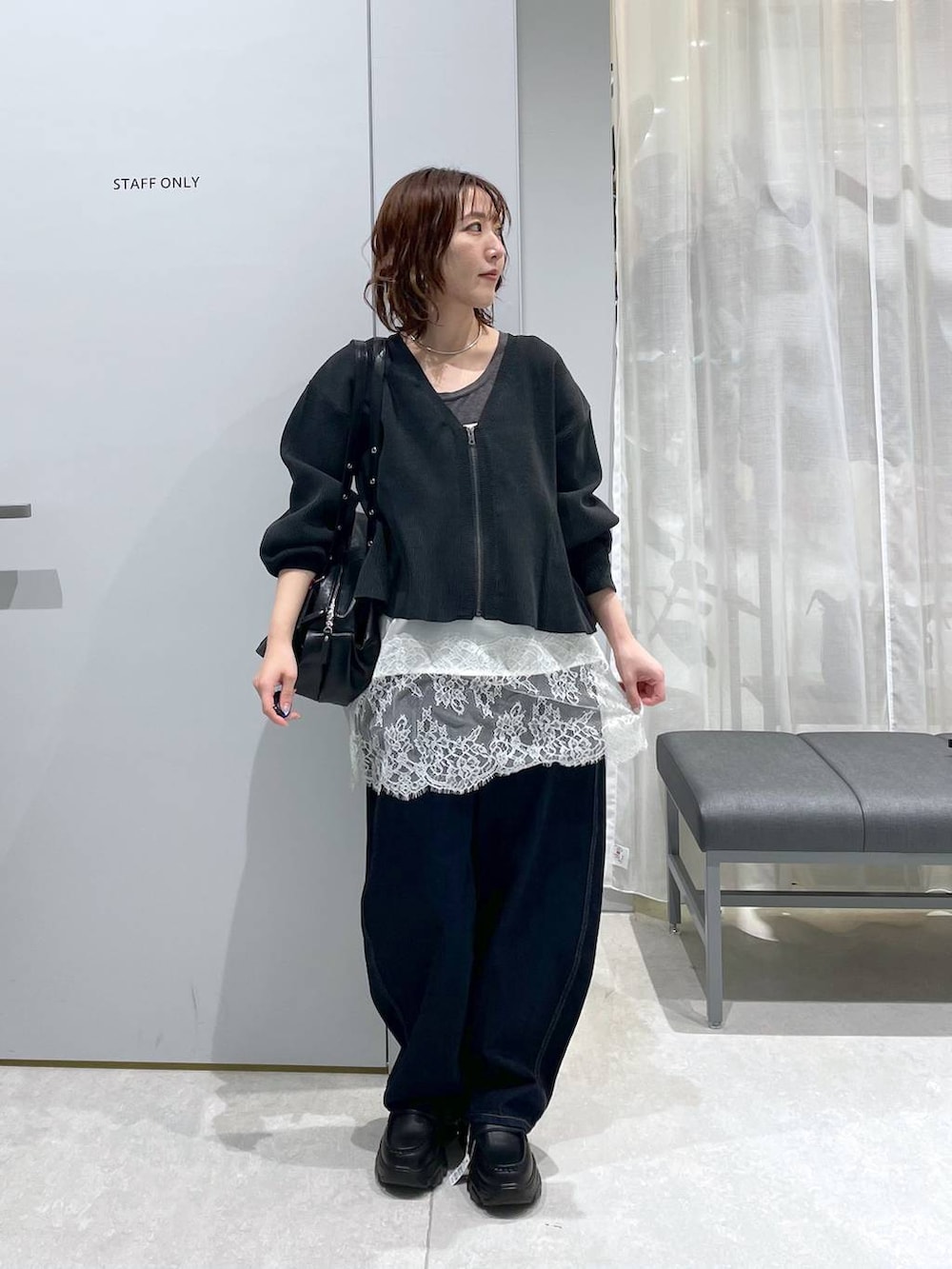 ブルー系のデニムパンツ、ブラック系のボストンバッグ、ブラック系のローファーを着用したレディースの冬コーディネートの2枚目の写真