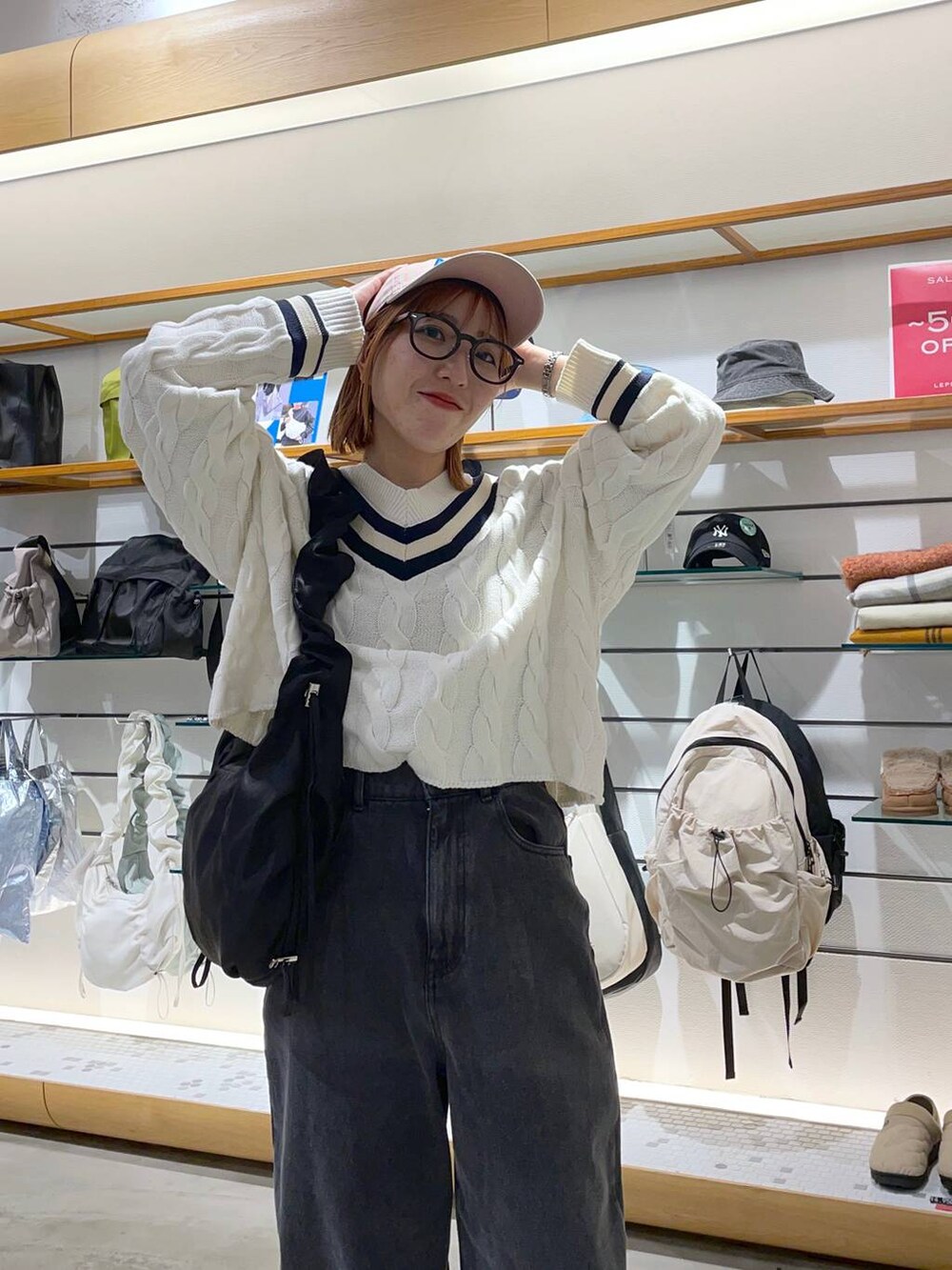 ホワイト系のニット/セーター、ブラック系のデニムパンツ、ホワイト系のスニーカーを着用したレディースの冬コーディネートの3枚目の写真