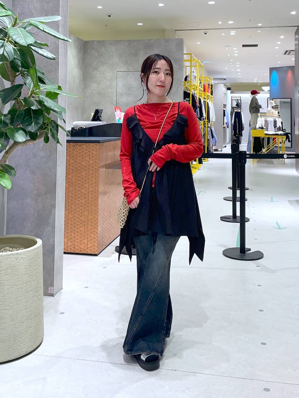 ブルー系のデニムパンツ、レッド系のTシャツ/カットソー、シルバー系のサンダルを着用したレディースの春コーディネートの2枚目の写真