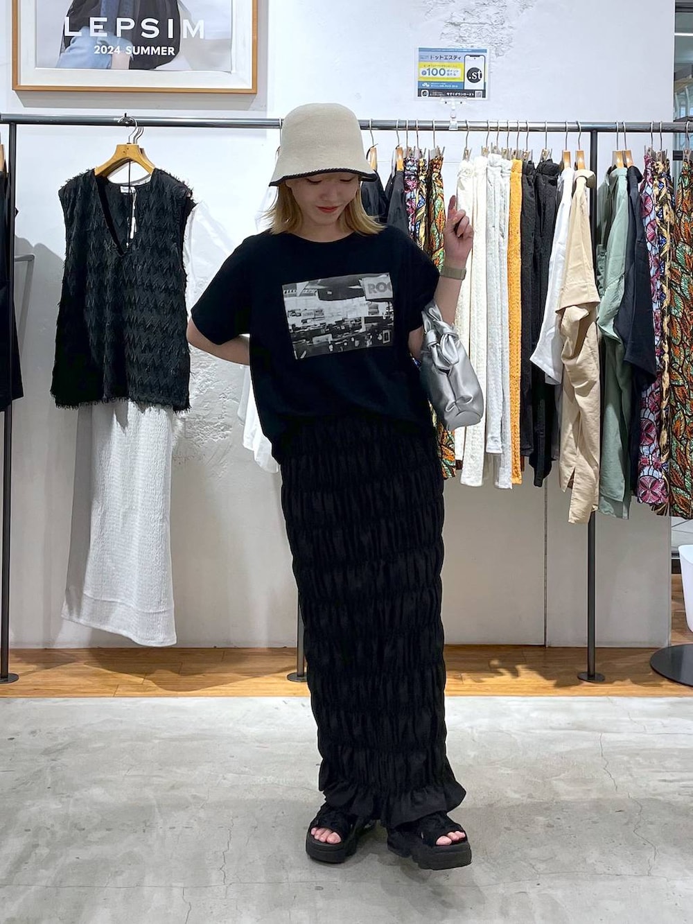 ブラック系のTシャツ/カットソー、ブラック系のスカート、シルバー系のショルダーバッグを着用したレディースの夏コーディネートの2枚目の写真