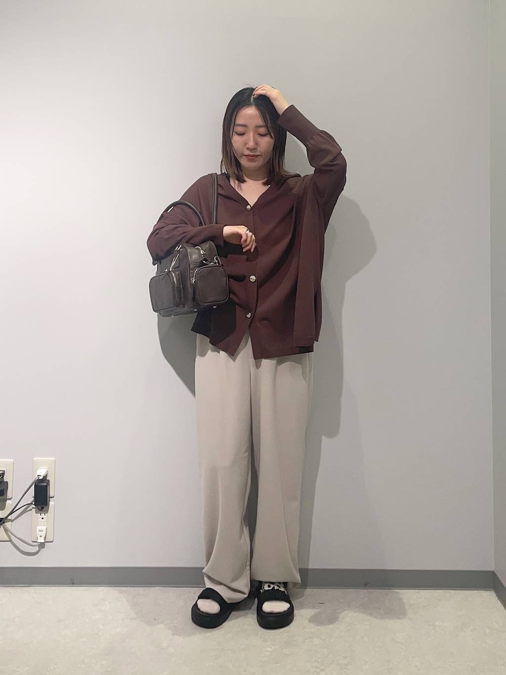 ベージュ系のその他パンツ、ブラウン系のボストンバッグ、ブラック系のサンダルを着用したレディースの春コーディネートの2枚目の写真