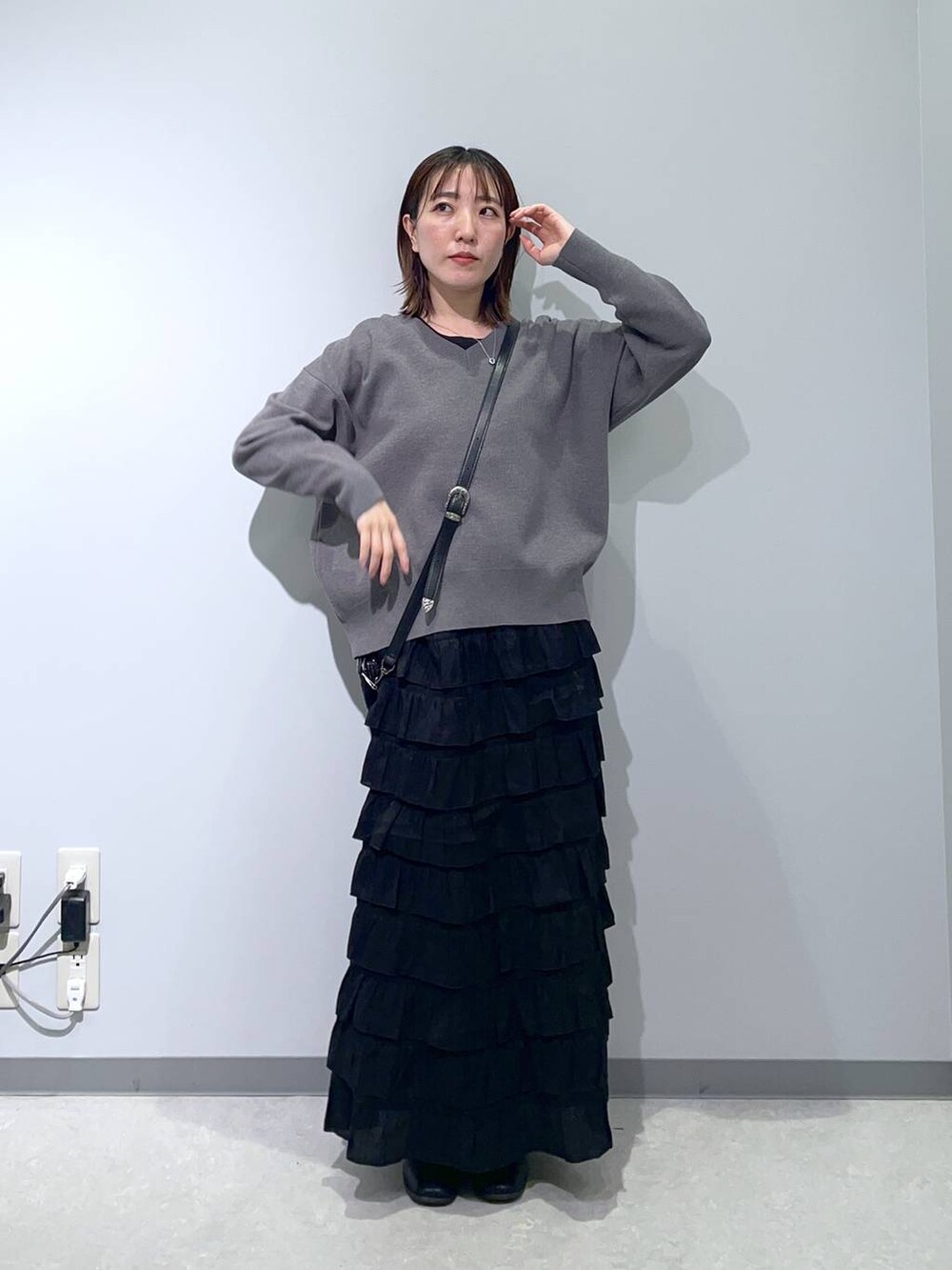 グレー系のスウェット、ブラック系のスカート、ブラック系のショルダーバッグを着用したレディースの冬コーディネートの3枚目の写真