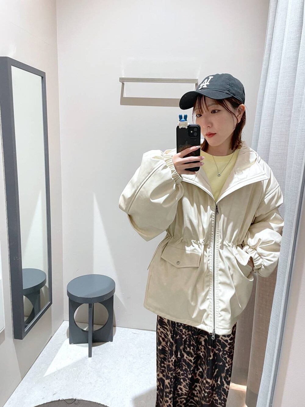 ブラウン系のスカート、ホワイト系のブルゾン、イエロー系のスウェットを着用したレディースの冬コーディネートの3枚目の写真