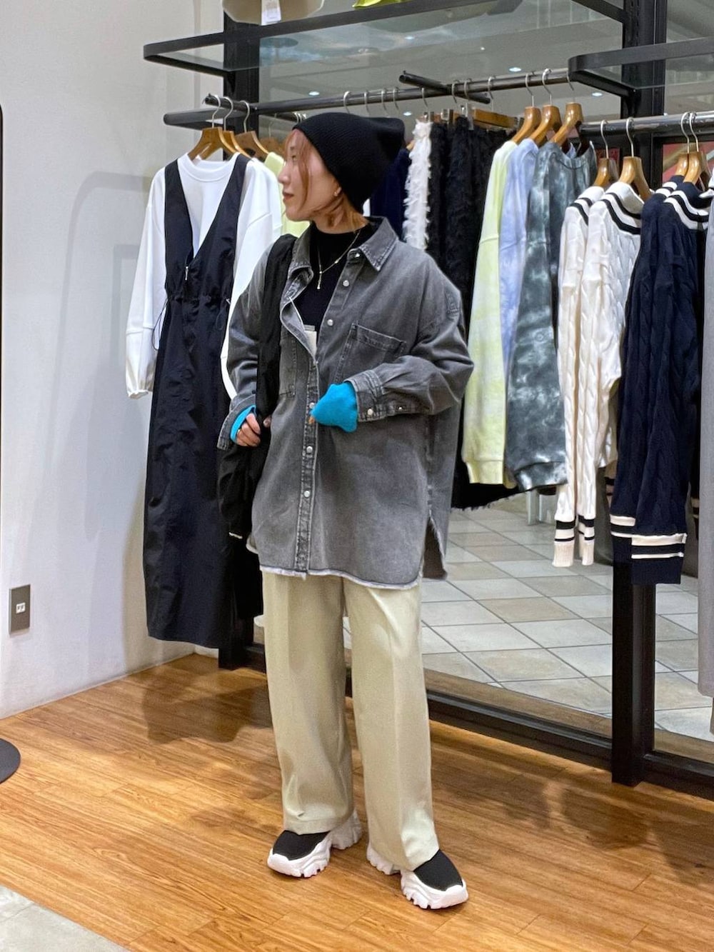 グレー系のシャツ/ブラウス、ブラック系のブーツ、ブラック系のショルダーバッグを着用したレディースの春コーディネートの2枚目の写真