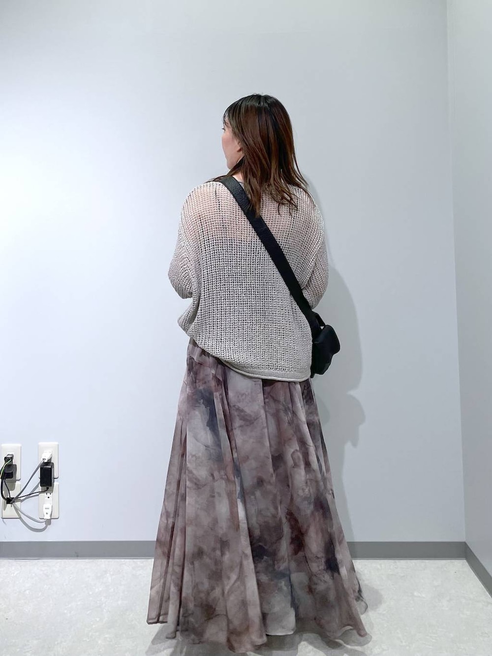 ブラック系のショルダーバッグ、グレー系のスカート、グレー系のニット/セーターを着用したレディースの春コーディネートの4枚目の写真