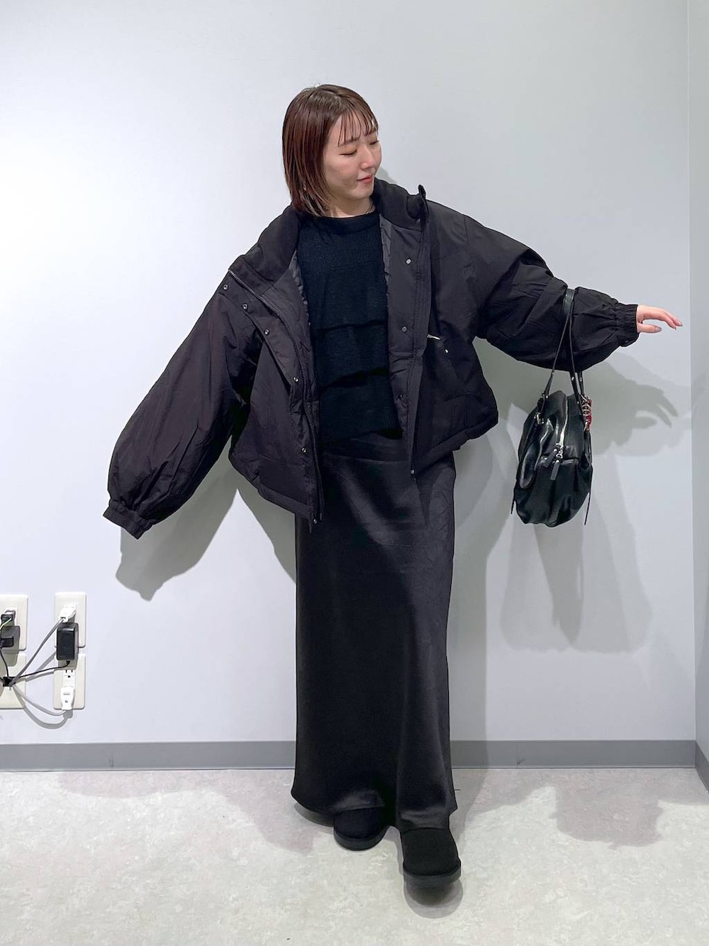 ブラック系のその他アウター、ブラック系のスカート、ブラック系のブーツを着用したレディースの冬コーディネートの2枚目の写真