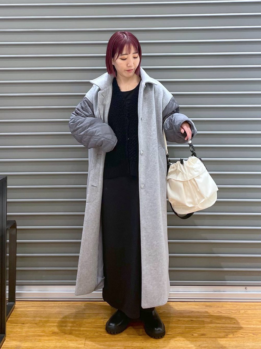 ブラック系のワンピース、ブラック系のブーツ、グレー系のその他アウターを着用したレディースの冬コーディネートの2枚目の写真