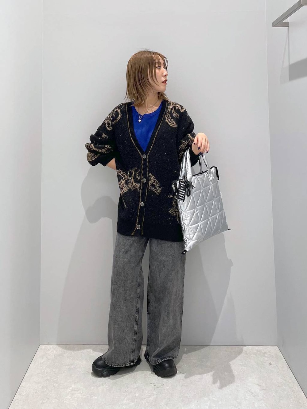 シルバー系のトートバッグ、ブラック系のカーディガン/ボレロを着用したレディースの秋コーディネートの2枚目の写真