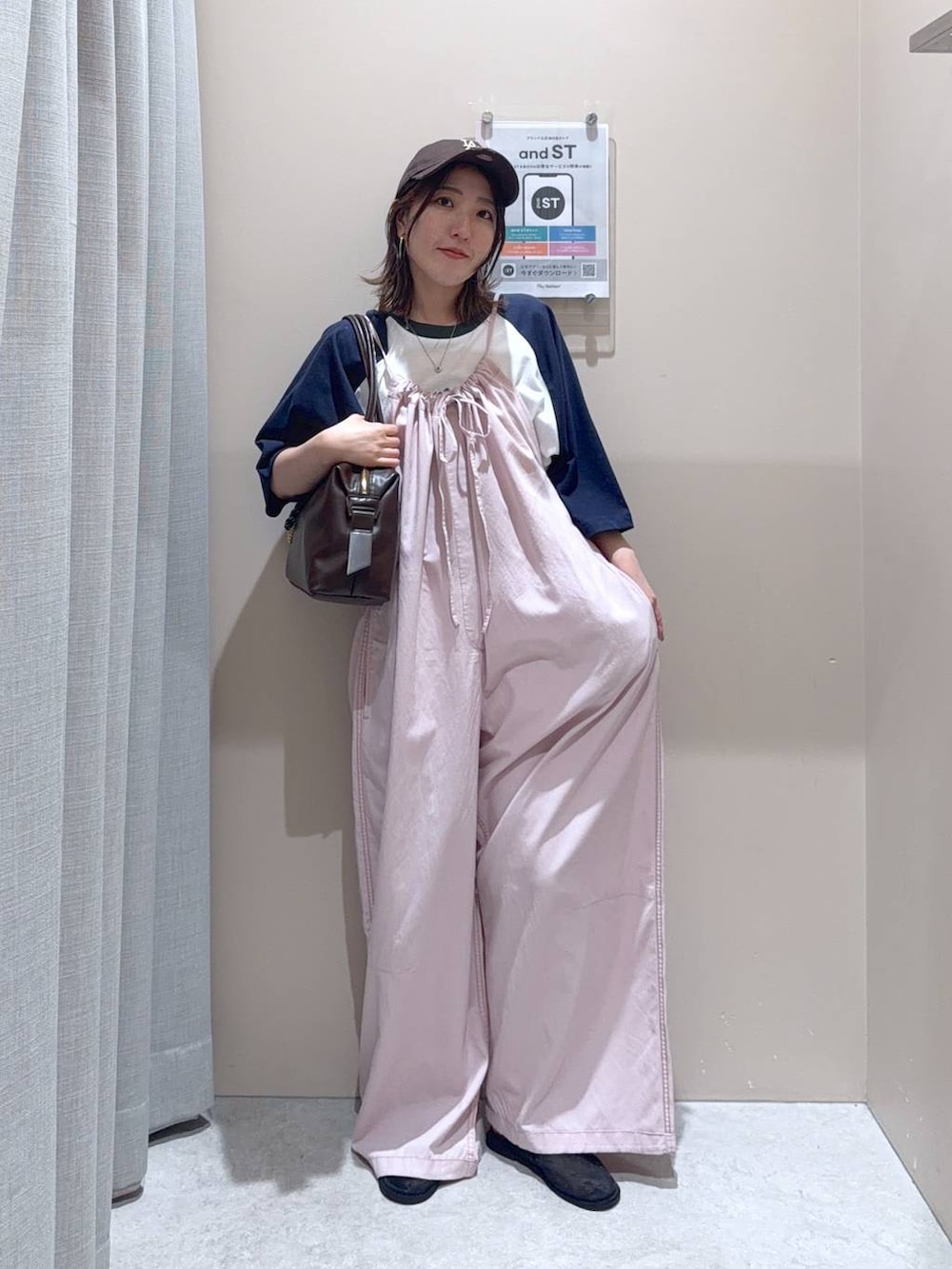 ブラウン系のボストンバッグ、ピンク系のサロペット/オーバーオール、ブルー系のTシャツ/カットソーを着用したレディースの夏コーディネートの3枚目の写真