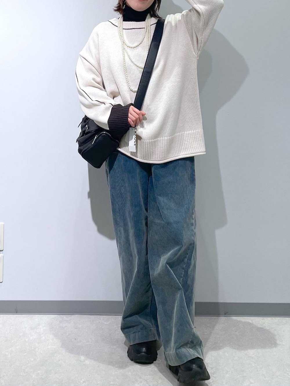 ブラック系のニット/セーター、ブルー系のその他パンツ、ブラック系のショルダーバッグを着用したレディースの冬コーディネートの3枚目の写真