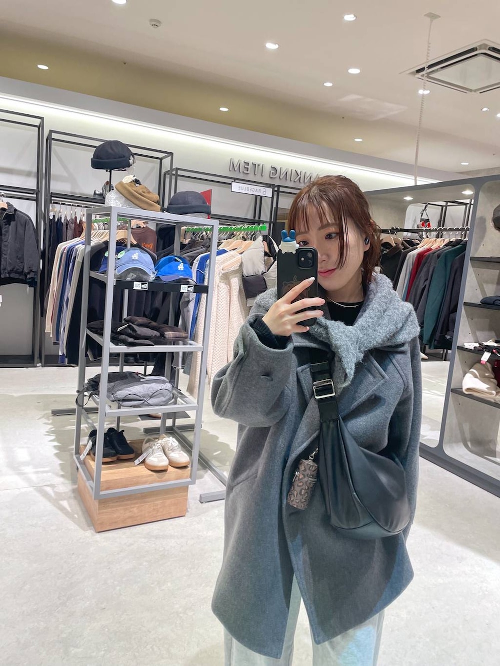 グレー系のピーコート、グレー系のスウェットパンツ、グレー系のストール/ショールを着用したレディースの冬コーディネートの3枚目の写真