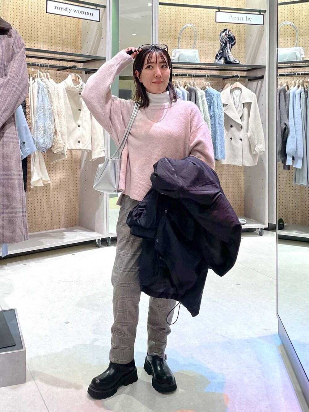 グレー系のその他パンツ、ホワイト系のTシャツ/カットソー、ブラック系のブーツを着用したレディースの冬コーディネートの6枚目の写真