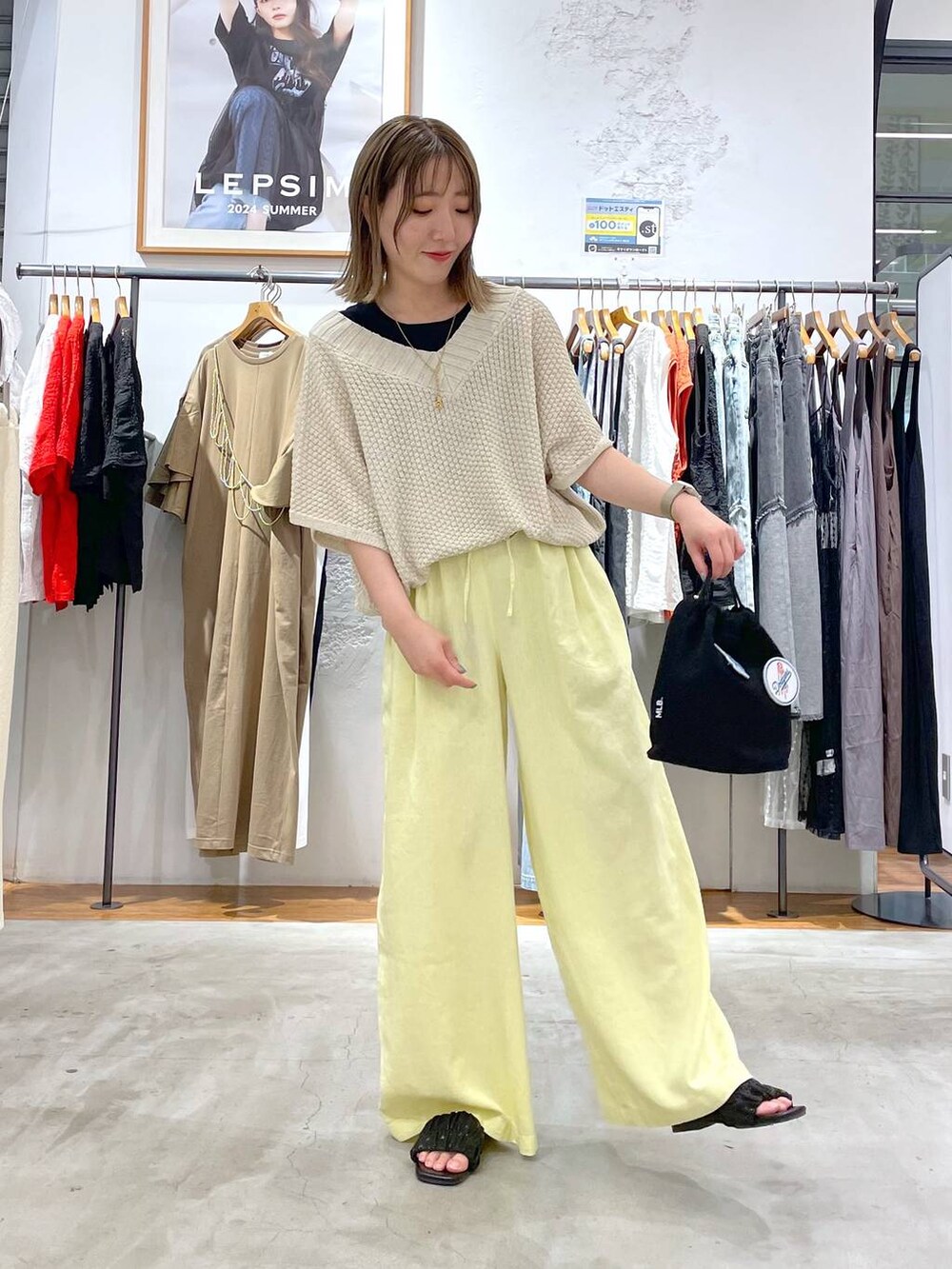 ブラック系のタンクトップ、イエロー系のその他パンツ、ブラック系のショルダーバッグを着用したレディースの夏コーディネートの2枚目の写真