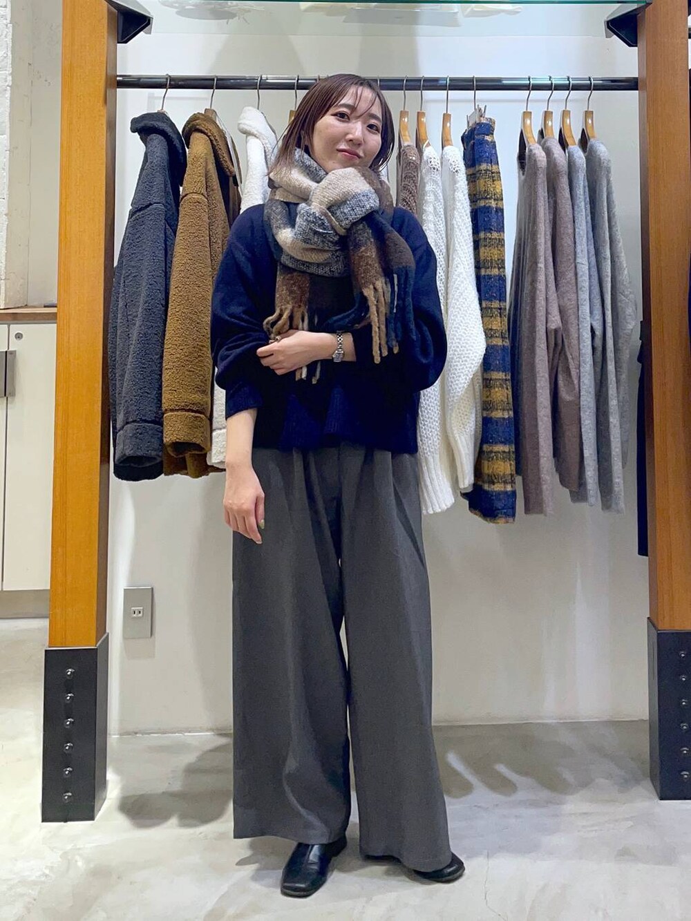 グレー系のその他パンツ、ブルー系のニット/セーター、ブラウン系のストール/ショールを着用したレディースの冬コーディネートの2枚目の写真