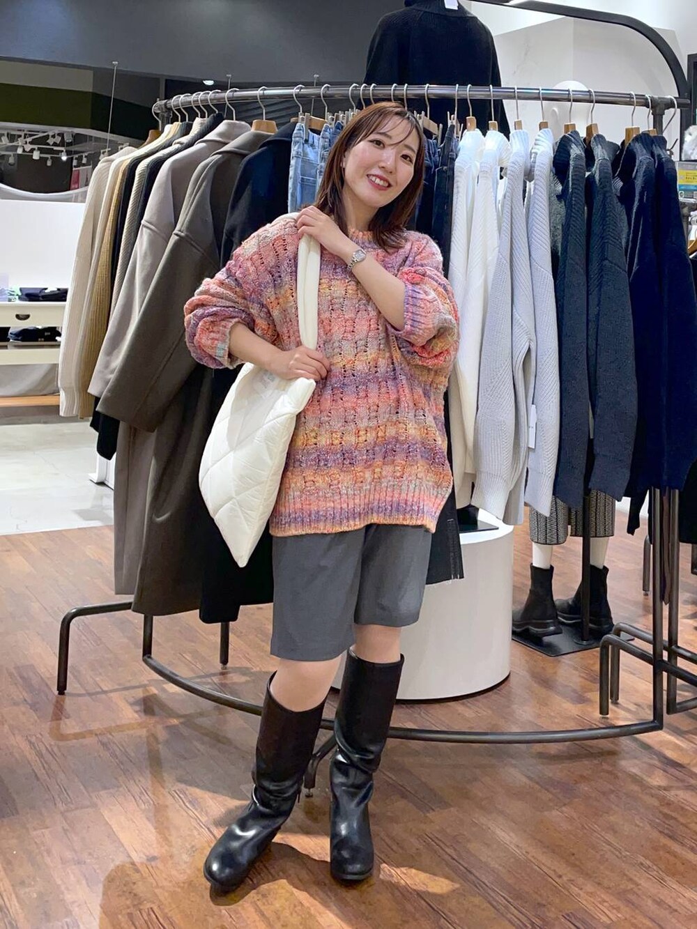 ブラック系のブーツ、ホワイト系のトートバッグ、グレー系のその他パンツを着用したレディースの冬コーディネートの2枚目の写真