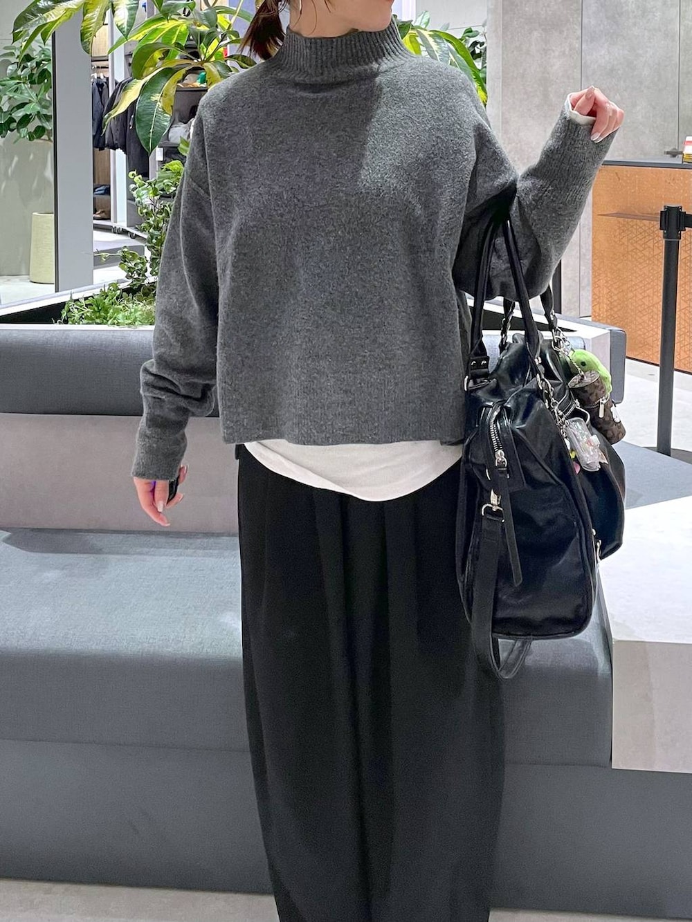 ホワイト系のTシャツ/カットソー、ブラック系のスラックス、グレー系のニット/セーターを着用したレディースの冬コーディネートの3枚目の写真