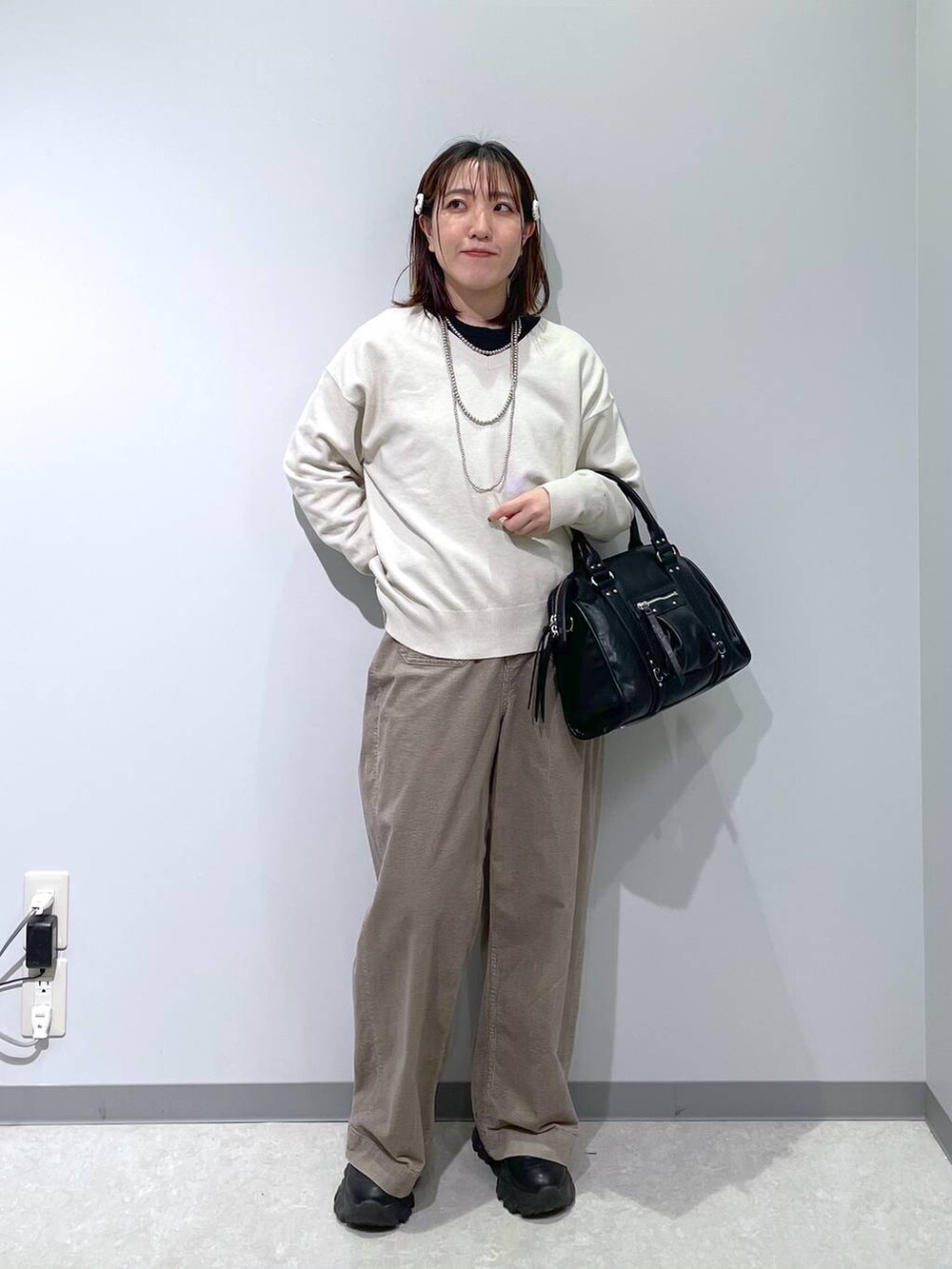 ブラック系のボストンバッグ、ベージュ系のその他パンツ、グレー系のニット/セーターを着用したレディースの冬コーディネートの3枚目の写真