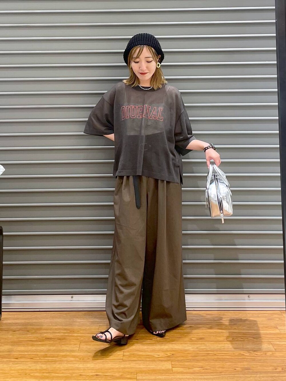 グレー系のその他トップス、ブラウン系のスラックス、シルバー系のボストンバッグを着用したレディースの夏コーディネートの2枚目の写真