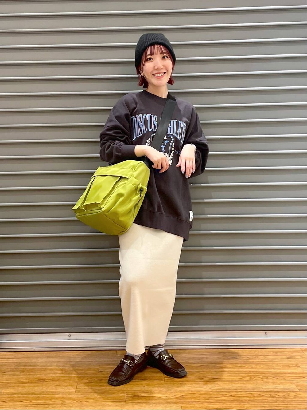 ホワイト系のスカート、グレー系のスウェット、グリーン系のショルダーバッグを着用したレディースの冬コーディネートの2枚目の写真