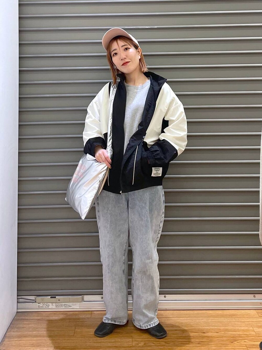 グレー系のTシャツ/カットソー、ブルー系のデニムパンツ、シルバー系のトートバッグを着用したレディースの冬コーディネートの3枚目の写真