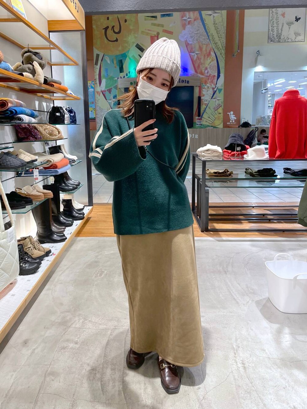 ベージュ系のスカート、グリーン系のニット/セーターを着用したレディースの冬コーディネートの2枚目の写真