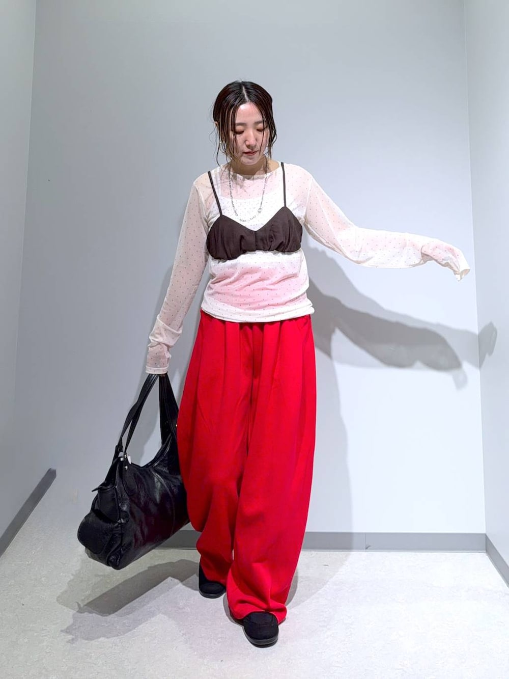 ブラック系のパンプス、ブラック系のトートバッグ、ブラウン系のその他トップスを着用したレディースの夏コーディネートの3枚目の写真