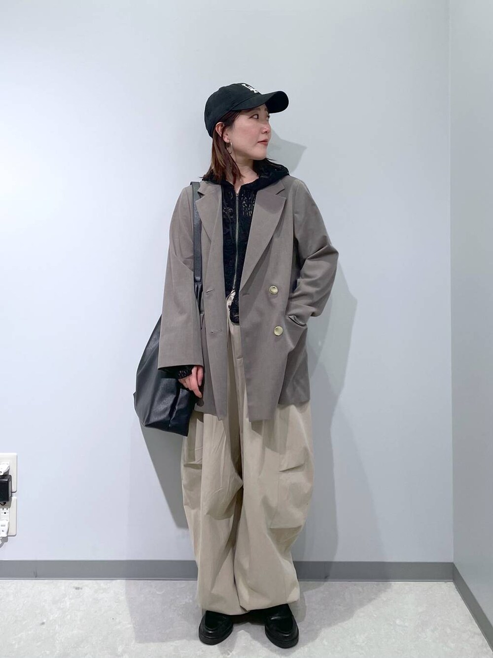 ブラック系のショルダーバッグ、ブラウン系のテーラードジャケット、ブラック系のパーカーを着用したレディースの春コーディネートの3枚目の写真