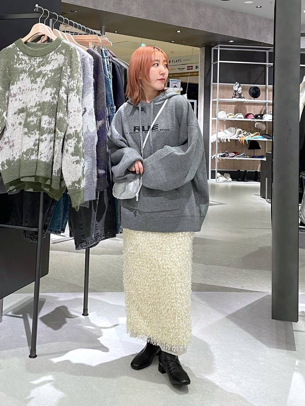 ベージュ系のスカート、グレー系のニット/セーターを着用したレディースの冬コーディネートの2枚目の写真