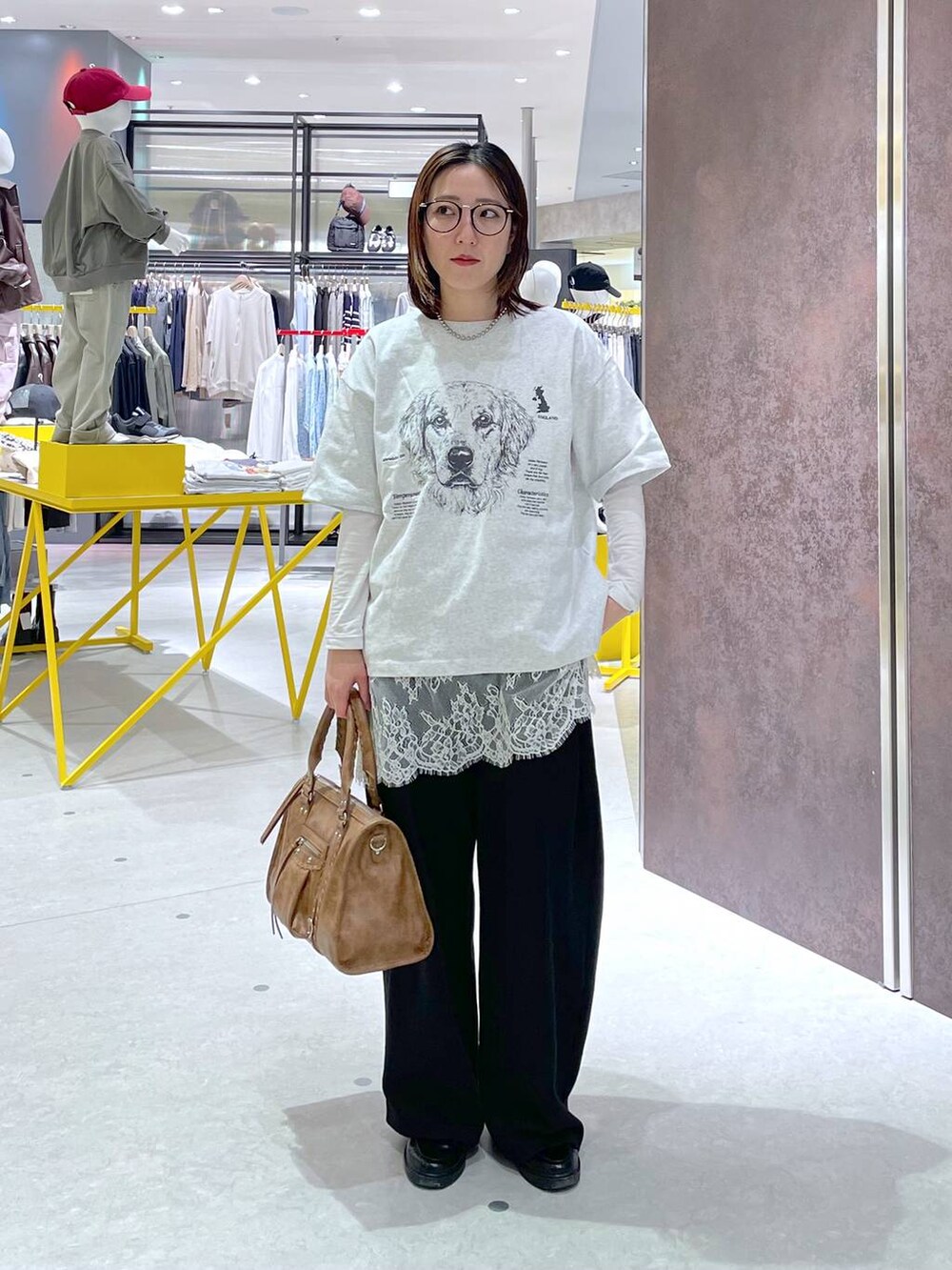 ホワイト系のキャミソール、ブラウン系のボストンバッグ、ブラック系のスウェットパンツを着用したレディースの春コーディネートの4枚目の写真